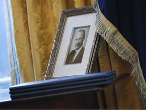 FILE - In this Feb. 9, 2017, file photo, a portrait of President Donald Trump's father Fred Trump, and three un-signed Executive orders are seen in the Oval Office of the White House in Washington. The New York Times is reporting that President Donald Trump received at least $413 million from his father over the decades, much of that through dubious tax dodges, including outright fraud.