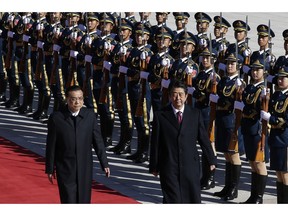 Japanese Prime Minister Shinzo Abe, right, and Chinese Premier Li Keqiang review an honor guard during a welcome ceremony at the Great Hall of the People in Beijing, Friday, Oct. 26, 2018.
