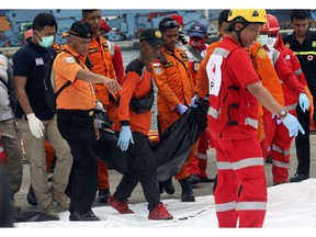Rescuers carry a body bag containing the remains recovered from the area where a Lion Air plane is suspected to crash, at Tanjung Priok Port in Jakarta, Indonesia, Tuesday, Oct. 30, 2018. Search and rescue personnel worked through the night to find victims of the Lion Air plane crash in Indonesia.