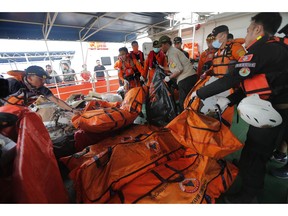 Rescuers load body bags containing debris and body parts onto a rescue ship during the search operations for victims of the crashed Lion Air plane in the waters of Ujung Karawang, Indonesia, Tuesday, Oct. 30, 2018. Divers searched Tuesday for victims of the Lion Air plane crash in Indonesia that killed a number of people and high-tech equipment was deployed to find its data recorders as reports emerged of problems on the jet's previous flight that had terrified passengers.
