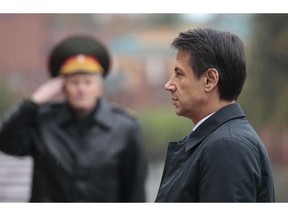 Italian Premier Giuseppe Conte, right, attends a wreath laying ceremony at the Tomb of the Unknown Soldier in Moscow, Russia, Wednesday, Oct. 24, 2018.