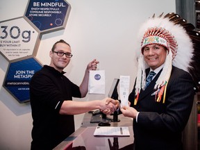 Onekanew (Chief) Christian Sinclair, right, of Opaskwayak Cree Nation, making a cannabis purchase at an unrelated store on the first day of legalization.