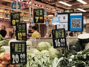 SIgns for Alipay sit alongside prices for produce at a Hong Kong market.