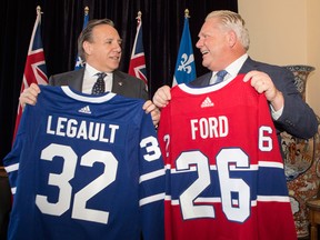 Quebec Premier Francois Legault, left, and Ontario Premier Doug Ford exchange hockey jerseys as a symbol of mutual cooperation.