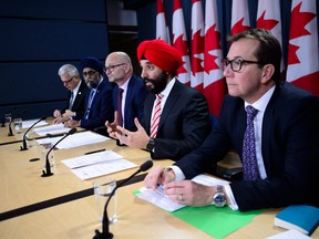 Navdeep Bains, centre, reacts to the Auditor General's report's conclusions.
