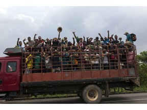 Central American migrants, part of the caravan hoping to reach the U.S. border, get a ride on a truck in Donaji, Oaxaca state, Mexico, Friday, Nov. 2, 2018. The migrants had already made a grueling 40-mile (65-kilometer) trek from Juchitan, Oaxaca, on Thursday, after they failed to get the bus transportation they had hoped for. But hitching rides allowed them to get to Donaji early, and some headed on to a town even further north, Sayula.
