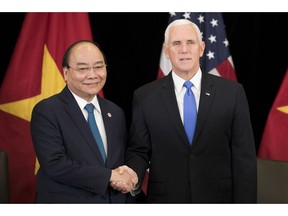 U.S. Vice President Mike Pence, right, shakes hands with Vietnam's Prime Minister Nguyen Xuan Phuc in Singapore, Wednesday, Nov. 14, 2018. Pence is Singapore to attend the 33rd ASEAN summit.