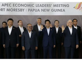 FILE - In this Nov. 18, 2018, file photo, Chinese President Xi Jinping, left, and U.S. Mike Pence, right, stand with other APEC leaders during the Economic Leaders Meeting in Port Moresby, Papua New Guinea. All the usual rituals of international summits were there _ the group photos, the gala dinners, the noticeably vibrant shirts leaders are asked to wear. But eclipsing all of that at two recent meetings was some unusually forthright criticism that exposed deepening divisions rattling the Asia-Pacific region.  The disharmony largely centered on the U.S. and China, who are locked in a widening trade war and whose representatives used the summits to exchange barbs with one another and maneuver to expand their influence.