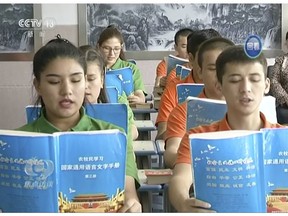 FILE - In this file image from undated video footage run by China's CCTV via AP Video, young Muslims read from official Chinese language textbooks in classrooms at the Hotan Vocational Education and Training Center in Hotan, Xinjiang, northwest China. China says 15 foreign ambassadors exceeded their diplomatic roles by issuing a letter expressing concern about the incarceration of hundreds of thousands of members of the country's Muslim minorities in re-education camps.