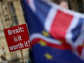 A demonstrator holds a sign that reads "Brexit. Is it worth it?" as he protests outside the Houses of Parliament in London in September. British and European Union negotiators have reached a draft agreement on Brexit.