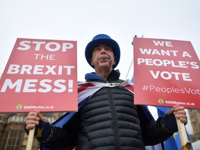 Anti-Brexit demonstrators hold placards calling for a "People's Vote" as they protest outside the Houses of Parliament in central London earlier this month.