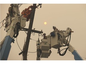 FILE - In this Friday, Nov. 9, 2018 file photo, Pacific Gas & Electric crews work to restore power lines in Paradise, Calif. A bill is being worked up to protect California utilities from possible bankruptcy over potentially billions in liability costs from the state's deadly wildfires. The San Jose Mercury News reports Tuesday, Nov. 20, 2018, that Assemblyman Chris Holden plans to introduce a measure allowing Pacific Gas & Electric and other utilities to pass onto customers some costs related to this year's wildfires.