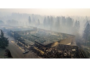 Smoke hangs over the scorched remains of Old Town Plaza following the wildfire in Paradise, Calif., on Thursday, Nov. 15, 2018. The shopping center housed a Safeway and other businesses.