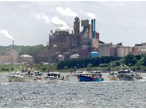 Fishing boats pass the Northern Pulp mill as concerned residents, fishermen and Indigenous groups protest the mill's plan to dump millions of litres of effluent daily into the Northumberland Strait in Pictou, N.S., on Friday, July 6, 2018. A group of fishermen from several ports along the Northumberland Strait say they will block a survey boat hired by Northern Pulp from entering the strait to do work on a proposed new route for an effluent pipe.