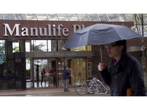 A pedestrian walks past the Manulife building in downtown Vancouver, B.C., Thursday, May 3, 2012.