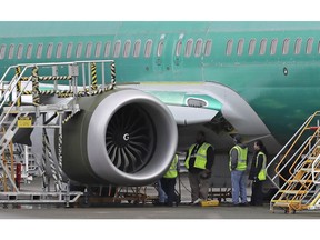 Workers stand next to a engine of a Boeing 737-MAX 8 at Boeing Co.'s 737 assembly facility in Renton, Wash., on November 14, 2018. WestJet Airlines Ltd. is joining the call for more information about a design issue -- which its own pilots were unaware of -- in the Boeing 737 Max, the aircraft at the centre of a deadly Lion Air crash last month. On Oct. 29, a Lion Air Max 8 passenger jet plunged into the Java Sea at high speed, just minutes after taking off from the Indonesian capital, Jakarta, killing all 189 people on board. Moments earlier, the pilot had requested permission to return to the airport because of a problem controlling the plane.