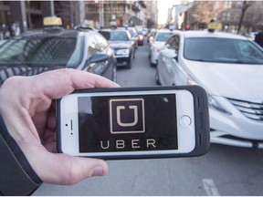Ride-hailing companies could begin operations in British Columbia by next fall under legislation introduced today. The Uber logo is seen in front of protesting taxi drivers at the courthouse in Montreal, Tuesday, Feb. 2, 2016.