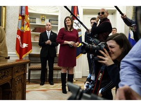 White House press secretary Sarah Huckabee Sanders watches as President Donald Trump speaks during a signing ceremony of the "Cybersecurity and Infrastructure Security Agency Act," in the Oval Office of the White House, Friday, Nov. 16, 2018, in Washington.