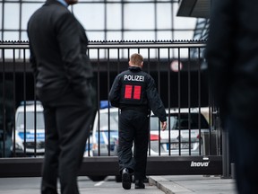 A police officer walks towards a security gate outside the headquarters of Deutsche Bank AG in Frankfurt, Germany, on Thursday. Deutsche Bank's premises including its headquarters in Frankfurt were being searched by prosecutors in a money laundering probe.