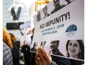 The Executive Board of the International Press Institute (IPI) gather to mark International Day to End Impunity for Crimes against Journalists at the SNP Square in Bratislava, Slovakia, Friday, Nov. 2, 2018. The Board called for justice in the murder of Jan Kuciak and all other murdered journalists. The bodies of 27-year-old Jan Kuciak and his fiancee Martina Kusnirova were found Feb. 25, 2018 in their house in the town of Velka Maca.