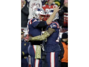 New England Patriots quarterback Tom Brady, left, celebrates his touchdown pass to wide receiver Josh Gordon, right, during the second half of an NFL football game against the Green Bay Packers, Sunday, Nov. 4, 2018, in Foxborough, Mass.