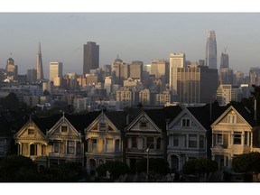FILE - This July 11, 2017, file photo, shows the skyline beyond a row of Victorian houses in San Francisco. A San Francisco couple has agreed to a $2.25 million legal settlement to the city for illegally renting out 14 apartments as Airbnb units. The San Francisco Chronicle reported Monday, Nov. 5, 2018, that a couple has agreed to pay the sum as penalties and investigation costs. San Francisco requires people renting their homes through sites like Airbnb to live in them at least 275 nights a year and rent them no more than 90 days during that time.