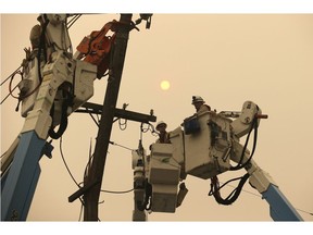 FILE - In this Friday, Nov. 9, 2018 file photo, Pacific Gas & Electric crews work to restore power lines in Paradise, Calif. A U.S. judge overseeing a criminal case against Pacific Gas & Electric Co. asked the utility Tuesday, Nov. 27, 2018, to explain any role it may have played in a massive wildfire that destroyed a Northern California town. Judge William Alsup in San Francisco directed PG&E in a court filing to respond to a series of questions about power line safety and wildfires.