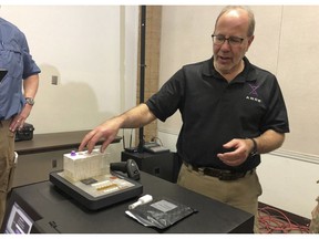 In this photo taken November 16, 2018, Stephen Meer, chief information officer from ANDE, demonstrates in Chico, Calif., his company's Rapid DNA analysis system, which is being used to try to ID victims of the Northern California wildfire. Authorities have deployed a powerful tool to aid in their race to identify the remains of 77 bodies burned in the deadly wildfire that ripped through Northern California: Rapid DNA testing that produces results in just two hours. But the technology that can match DNA to bone fragments in as little as two hours is only as effective as the numbers of people who show up to give a sample, and so far there are not nearly enough volunteers.