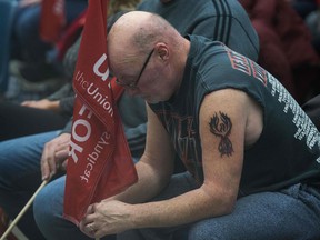 Carl Dillmam, who has worked at the General Motors plant for 37 years, sits with union members at a rally in Oshawa Monday after learning the plant would be shuttered in 2019.