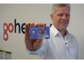 In this Oct. 17, 2018 photo, Alex Zivoder, CEO of Gohenry, a digital banking startup aimed at children, holds up a sample of the prepaid debit cards that the app comes with, in London. A wave of digital pocket money apps that come with prepaid cards are new tools for financial education as money increasingly goes digital, in a shift that's raising uncertainty about how cashless transactions affect youngsters' view of money.