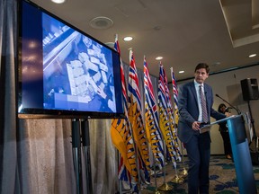 B.C. Attorney General David Eby speaks as a video is shown of bundles of cash brought to a casino by a person, after releasing an independent review of anti-money laundering practices during a news conference in Vancouver, on Wednesday June 27, 2018.