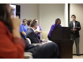 In this Aug. 23, 2018, photo Jim Baker, far right, a campaigner at the Private Equity Stakeholder Project listens as former Toys R Us employee Karen Brown speaks during the public comments portion of an investment advisory committee meeting of the North Carolina Department of State Treasurer in Raleigh, N.C. Two private equity owners of Toys R Us announced Tuesday, Nov. 20, that they will be handing over a $20 million hardship fund to the thousands of former workers left jobless and without severance after the chain liquidated in June.
