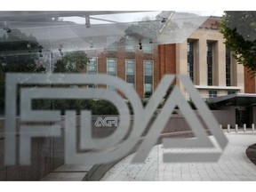 This Thursday, Aug. 2, 2018 photo shows the U.S. Food and Drug Administration building behind FDA logos at a bus stop on the agency's campus in Silver Spring, Md. An AP analysis of FDA data shows that since 2012, tens of thousands of injury and death reports have been filed in connection with devices that were cleared through a streamlined pathway that minimizes clinical trial testing.