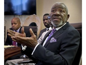 William Charles Blocker, right, one of eight plaintiffs in a lawsuit against Saks Fifth Avenue department store, speaks during a press conference at his lawyer's office, Tuesday Nov. 20, 2018, in New York. The lawsuit charges that Saks, which is owned by Hudson's Bay Company, subjected the men to unlawful age and race discrimination, a hostile work environment and unlawful retaliation.