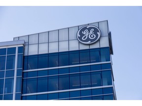 FILE- In this Jan. 16, 2018, file photo, the General Electric logo is displayed at the top of their Global Operations Center in the Banks development of downtown Cincinnati. General Electric is shuffling leadership at its power unit as it moves to split the division in its ongoing effort to slim down operations.