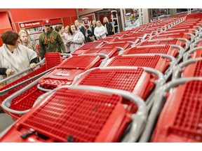 FILE- In this Friday, Nov. 23, 2018, file photo, shoppers enter and take their shopping carts during a Black Friday sale at a Target store in Newport, Ky. On Tuesday, Nov. 27, the Conference Board releases its November index on U.S. consumer confidence.