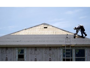 FILE- In this July 23, 2018, file photo a construction worker puts down roofing paper on a new home as he works outside in Houston. On Tuesday, Nov. 20, the Commerce Department reports on U.S. home construction in October.