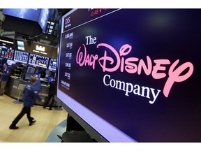 FILE - In this Aug. 8, 2017, file photo, the Walt Disney Co. logo appears on a screen above the floor of the New York Stock Exchange. The Walt Disney Co. reports earnings Thursday, Nov. 8.