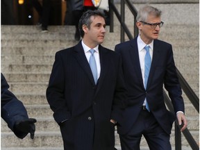 Michael Cohen, left, walks out of federal court with his attorney Guy Petrillo, Thursday, Nov. 29, 2018, in New York, after pleading guilty to lying to Congress about work he did on an aborted project to build a Trump Tower in Russia.  Cohen, President Donald Trumps former lawyer, told the judge he lied about the timing of the negotiations and other details to be consistent with Trump's "political message."