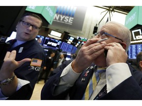 FILE- In this Friday, Nov. 9, 2018, file photo trader Thomas Ferrigno, right, and specialist Gregg Maloney work on the floor of the New York Stock Exchange. The U.S. stock market opens at 9:30 a.m. EDT on Tuesday, Nov. 13.