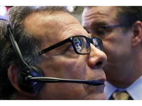 FILE- In this Oct. 25, 2018, file photo the NYSE and Yeti logos are reflected in the glasses of trader Sal Suarino as he works on the floor of the New York Stock Exchange. The U.S. stock market opens at 9:30 a.m. EDT on Thursday, Nov. 1.