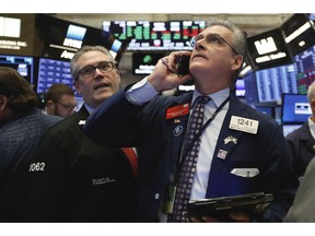 FILE- In this Nov. 8, 2018, file photo traders Eric Schumacher, left, and Richard Deviccaro work on the floor of the New York Stock Exchange. The U.S. stock market opens at 9:30 a.m. EDT on Friday, Nov. 16.