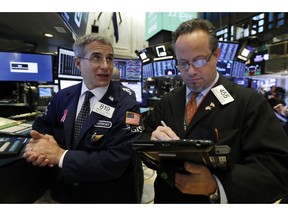 FILE- In this Friday, Nov. 9, 2018, file photo specialist Antony Rinaldi left, and trader Robert Arciero work on the floor of the New York Stock Exchange. The U.S. stock market opens at 9:30 a.m. EDT on Friday, Nov. 23.