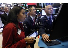 Trader Lauren Simmons, left, woks with specialists Lauren Simmons on the floor of the New York Stock Exchange, Thursday, Nov. 8, 2018. Stocks are opening modestly lower on Wall Street as the market gives back some of its big gains from the day before.