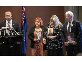 Pike River Re-entry Minister Andrew Little, left, stands with Pike River family members Anna Osborne, second from left, Sonya Rockhouse, second from right, and Bernie Monk, right, at the announcement of a re-entry plan at parliament in Wellington, New Zealand, Wednesday, Nov. 14, 2018. Eight years after a gas explosion in a coal mine killed 29 workers, New Zealand's government says crews will re-enter the mine to better understand what went wrong and hopefully recover some of the bodies.