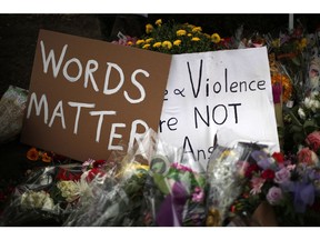 Flowers surround signs on Wednesday, Oct. 31, 2018, part of a makeshift memorial outside the Tree of Life Synagogue to the 11 people killed during worship services Saturday Oct. 27, 2018 in Pittsburgh.