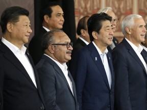From left, Chinese President Xi Jinping, Papua New Guinea's Prime Minister Peter O'Neill, Japanese Prime Minister Shinzo Abe, and U.S. Vice President Mike Pence pose for a group photo at APEC Haus in Port Moresby, Papua New Guinea, Sunday, Nov. 18, 2018.