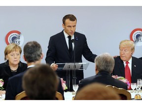 German Chancellor Angela Merkel and President Donald Trump listen to French President Emmanuel Macron delivering a speech before a lunch at the Elysee Palace in Paris during commemorations marking the 100th anniversary of the 11 November 1918 armistice, ending World War I, Sunday, Nov. 11, 2018.