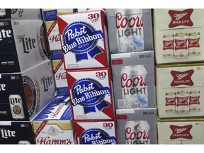 In this photo taken on Thursday, Nov. 8, 2018, cases of Pabst Blue Ribbon and Coors Light are stacked next to each other in a Milwaukee liquor store. Pabst Brewing Company and MillerCoors are heading to trial starting Monday, Nov. 12, to settle a contract dispute in which Pabst accuses the brewing giant of trying to undermine its competitor by breaking a contract to make their products.