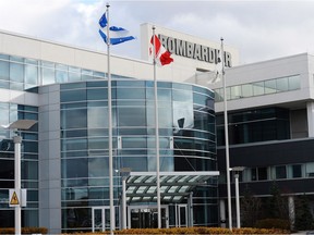 Flags fly outside a Bombardier plant in Montreal, Thursday, November 8, 2018. Bombardier Inc. says it's cutting about 5,000 jobs across the organization over the next 12 to 18 months as part of a new restructuring plan.